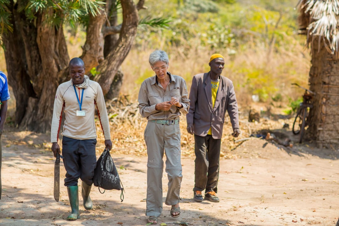 Upendo staff walking with beekeepers through a village